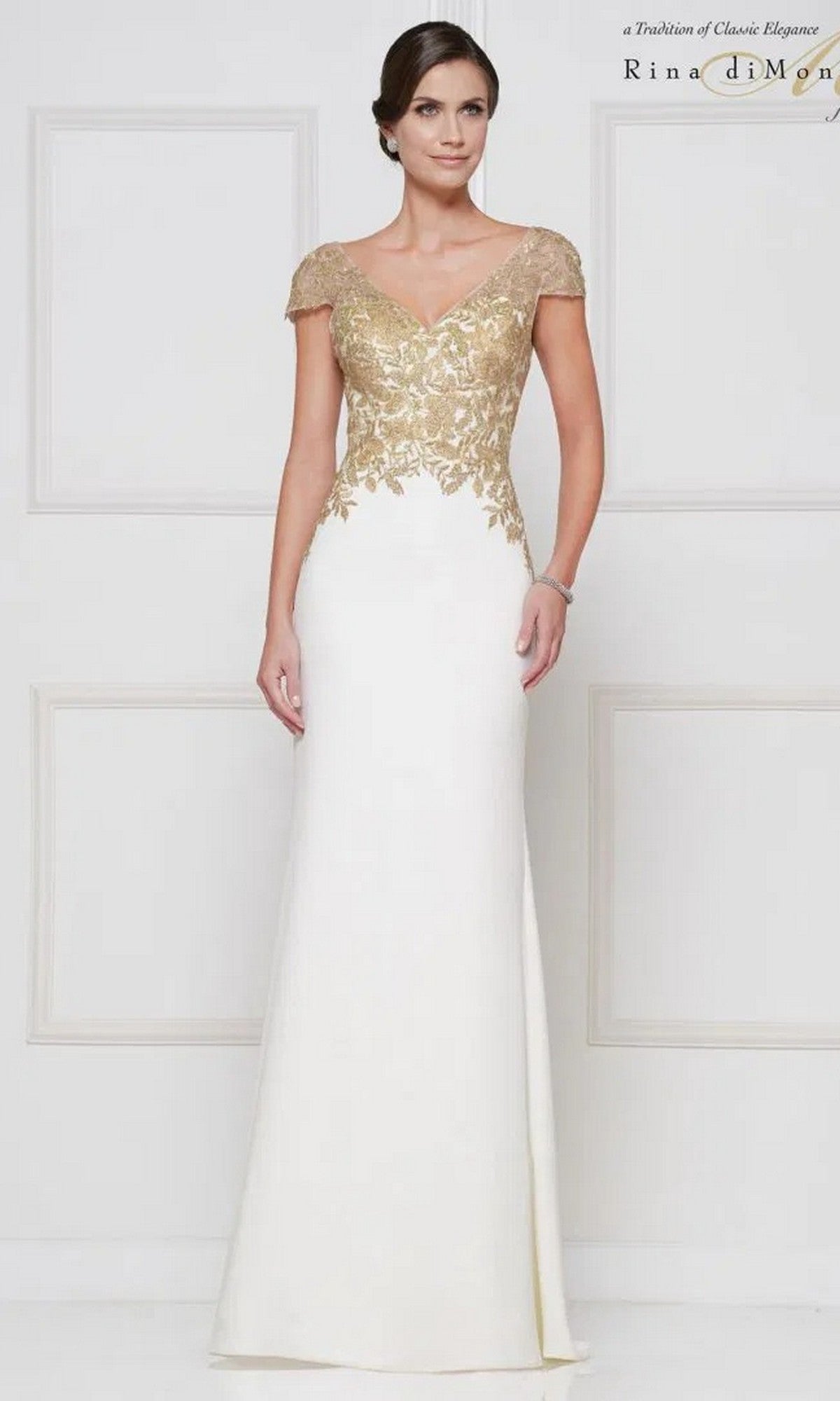 A woman models the Long Formal Dress: Rina Di Montella RD2652 in Ivory & Gold, featuring a floor-length sheath silhouette with gold-embroidered lace bodice and cap sleeves, standing against a plain white background.